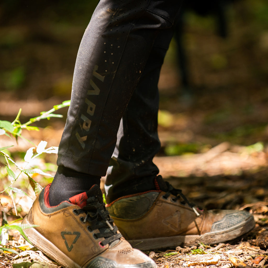 Detalle bota de pantalon de MTB negro, repelenta al agua.